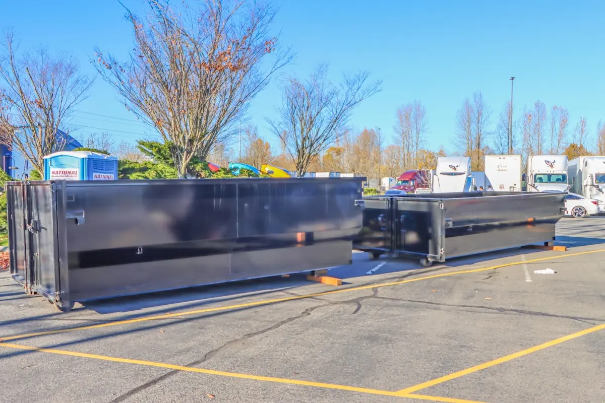 Professional dumpster rental service with roll-off container on residential driveway in South Hadley